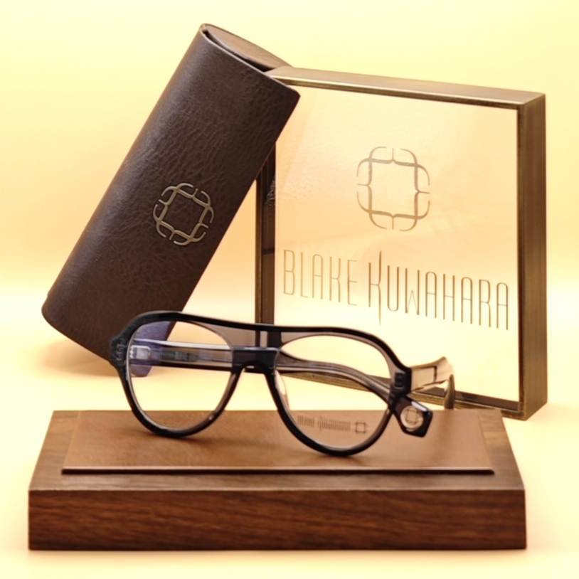 Blake Kuwahara's Albini sunglasses or optical frames with an inverted-aviator shape and a thick black browline over clear lower lenses.