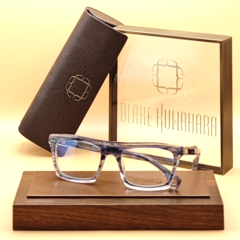 Blake Kuwahara's Meyer wide rectangular optical frame in a grey, blue, and white striated, transparent acetate.