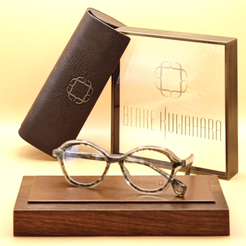 Blake Kuwahara's Bardi round/oval optical frames in a light grey and sage green marbled acetate pattern.