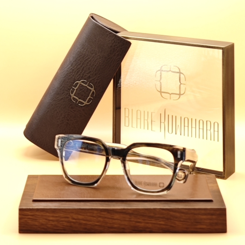 Blake Kuwahara's Kesling rectangular glasses with a dark brown/black tortoise browline over a clear lower rim.