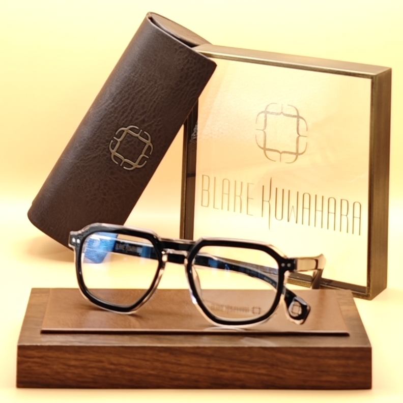 Blake Kuwahara's Thayer geometric hexagonal glasses with a thick black outer rim layered over a clear inner frame.