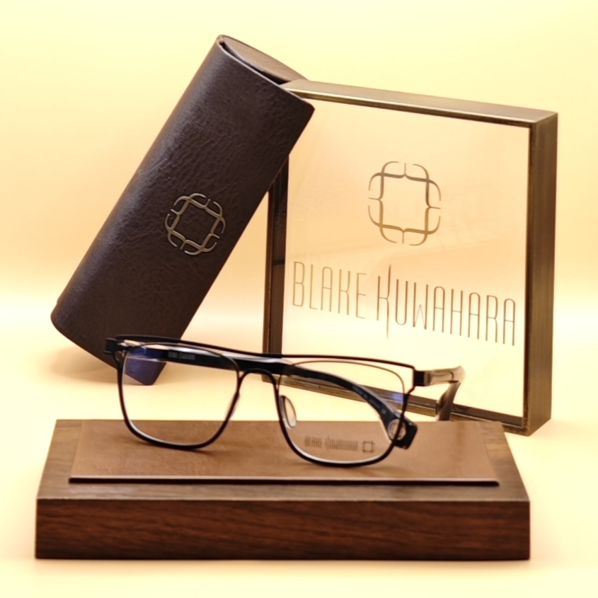 Blake Kuwahara's Volk glasses with a slim, black metal and acetate rectangular frame.