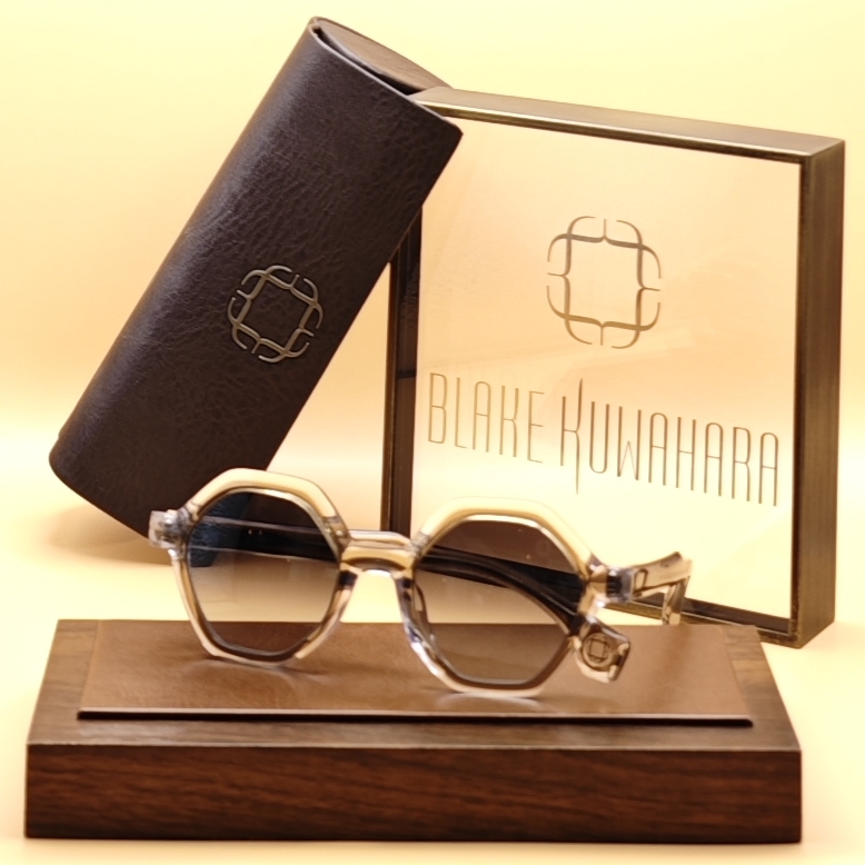 Blake Kuwahara Noyes lightly-tinted octagonal sunglasses with a thick beige/off-white top layer and clear lower frame.