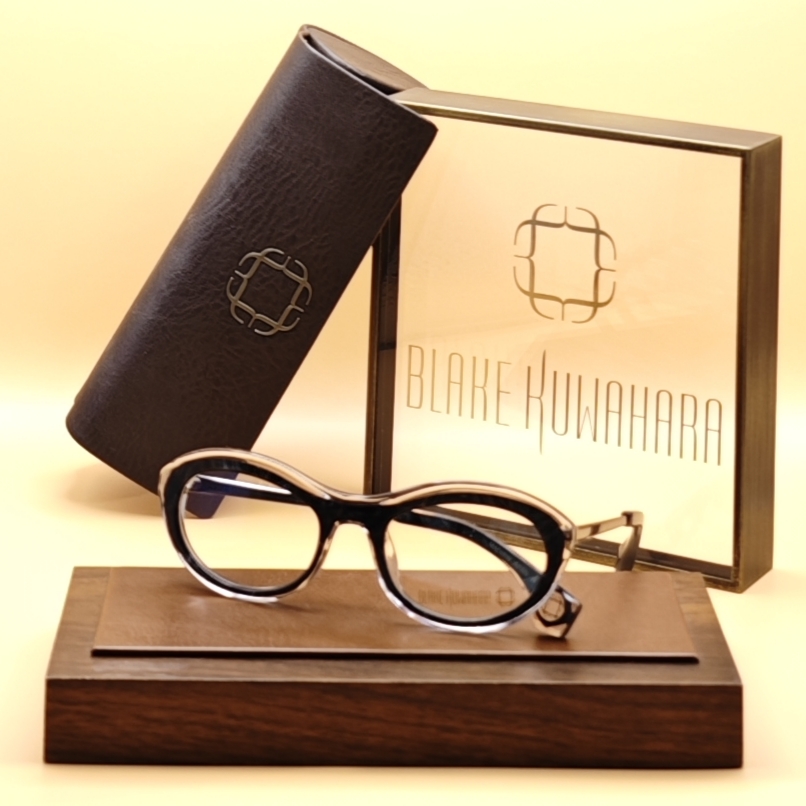 Blake Kuwahara's Kuma oval cat-eye glasses in a two-layer black and clear acetate design with gold temple accents.