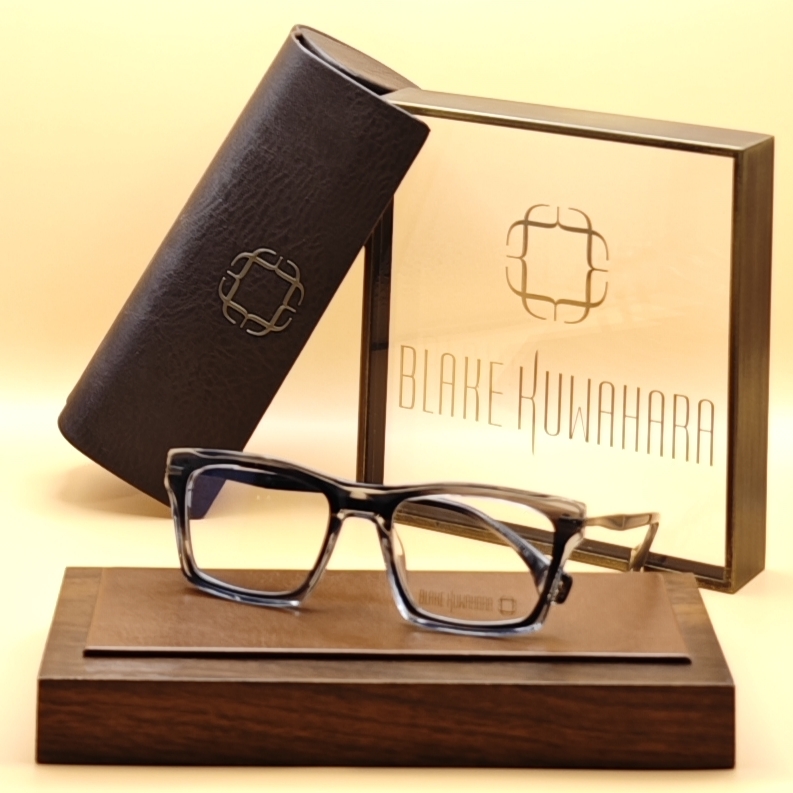 Blake Kuwahara's Webster chunky square glasses in a Grey, white, and clear striated/marbled acetate pattern.