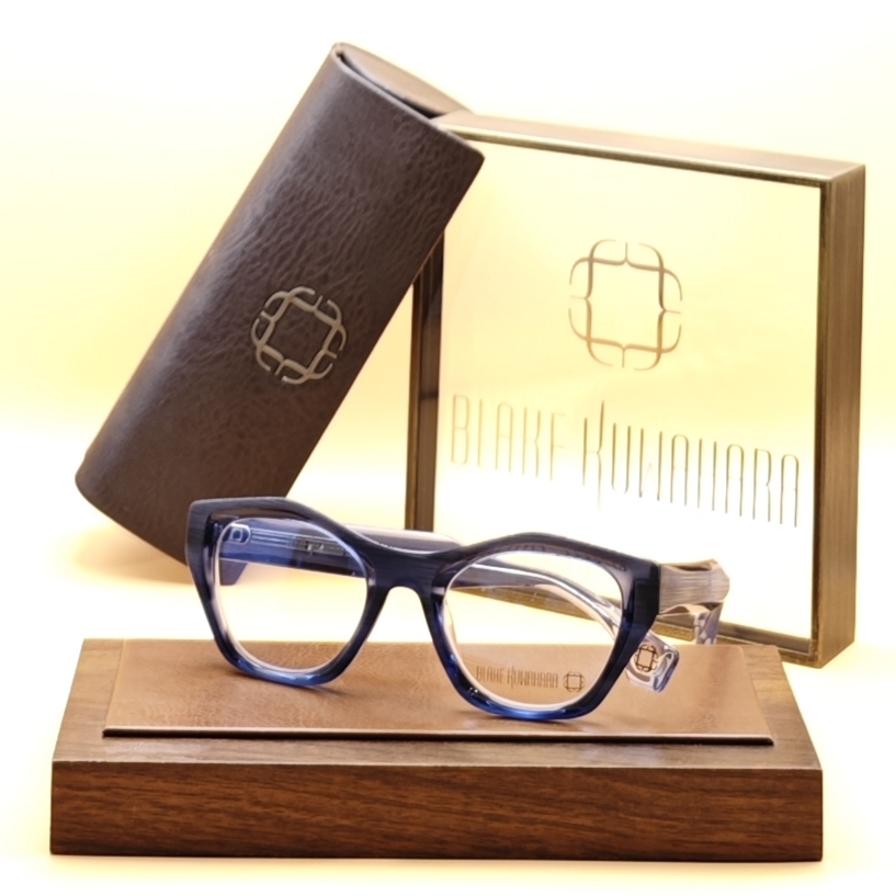 Blake Kuwahara's BK 1035 oval cat-eye glasses in a two-layer blue and clear acetate design with gold temple accents.